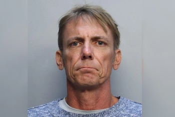 Un hombre caucásico de mediana edad, con cabello rubio peinado hacia un lado y una camiseta de cuello redondo azul y gris, mira al frente