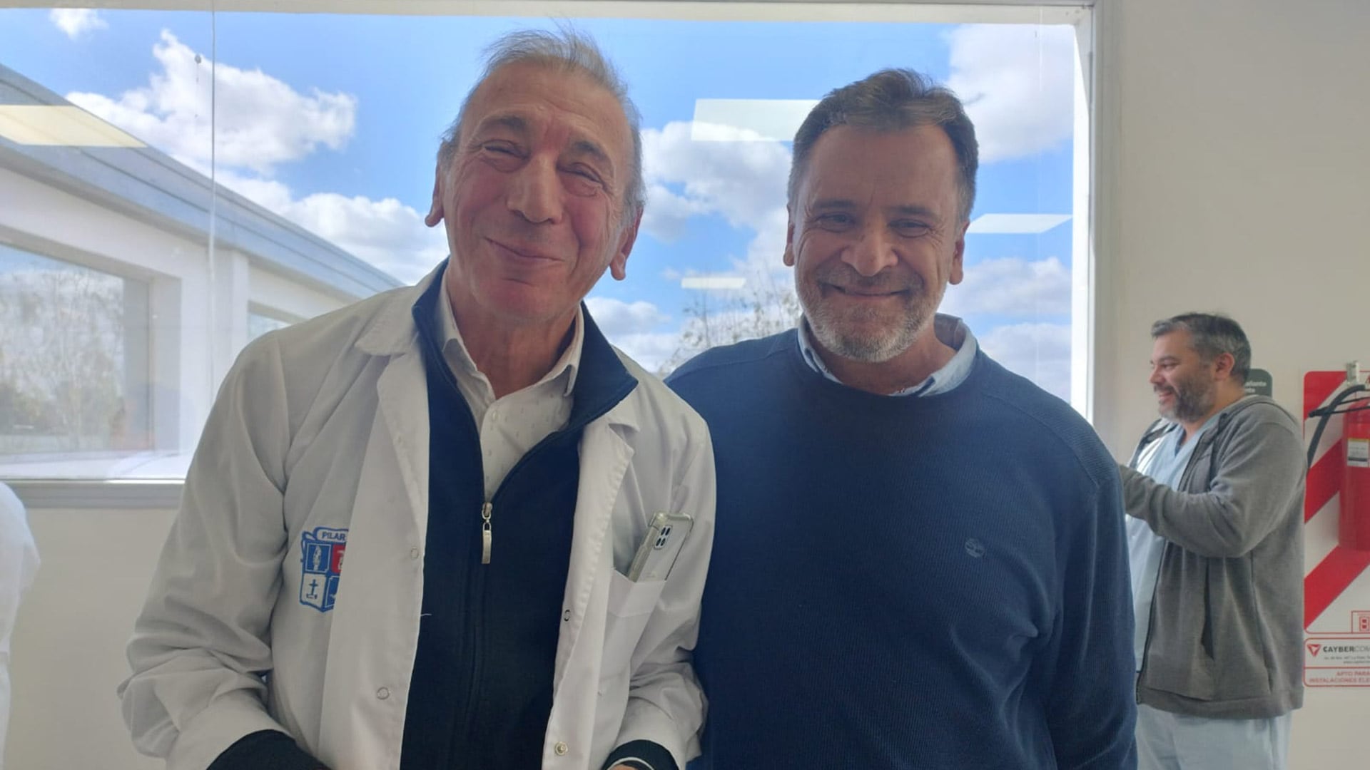 Vocación médica: el cardiólogo intervencionista posa en el ámbito laboral del hospital junto a un compañero de trabajo.
