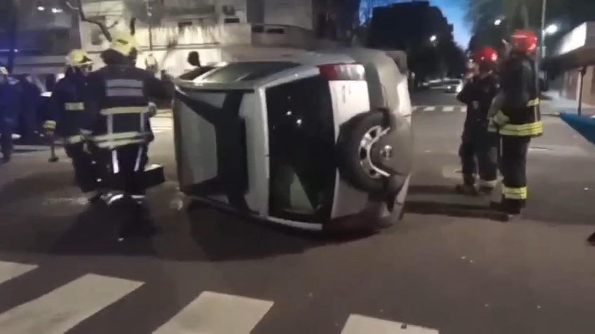 Bomberos asisten en la escena de un accidente automovilístico donde un vehículo quedó volcado sobre su techo en una calle de Parque Patricios.