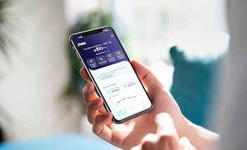 Mano que sostiene un teléfono inteligente con la pantalla de la billetera digital dale! y gráficos de tasa de cambio