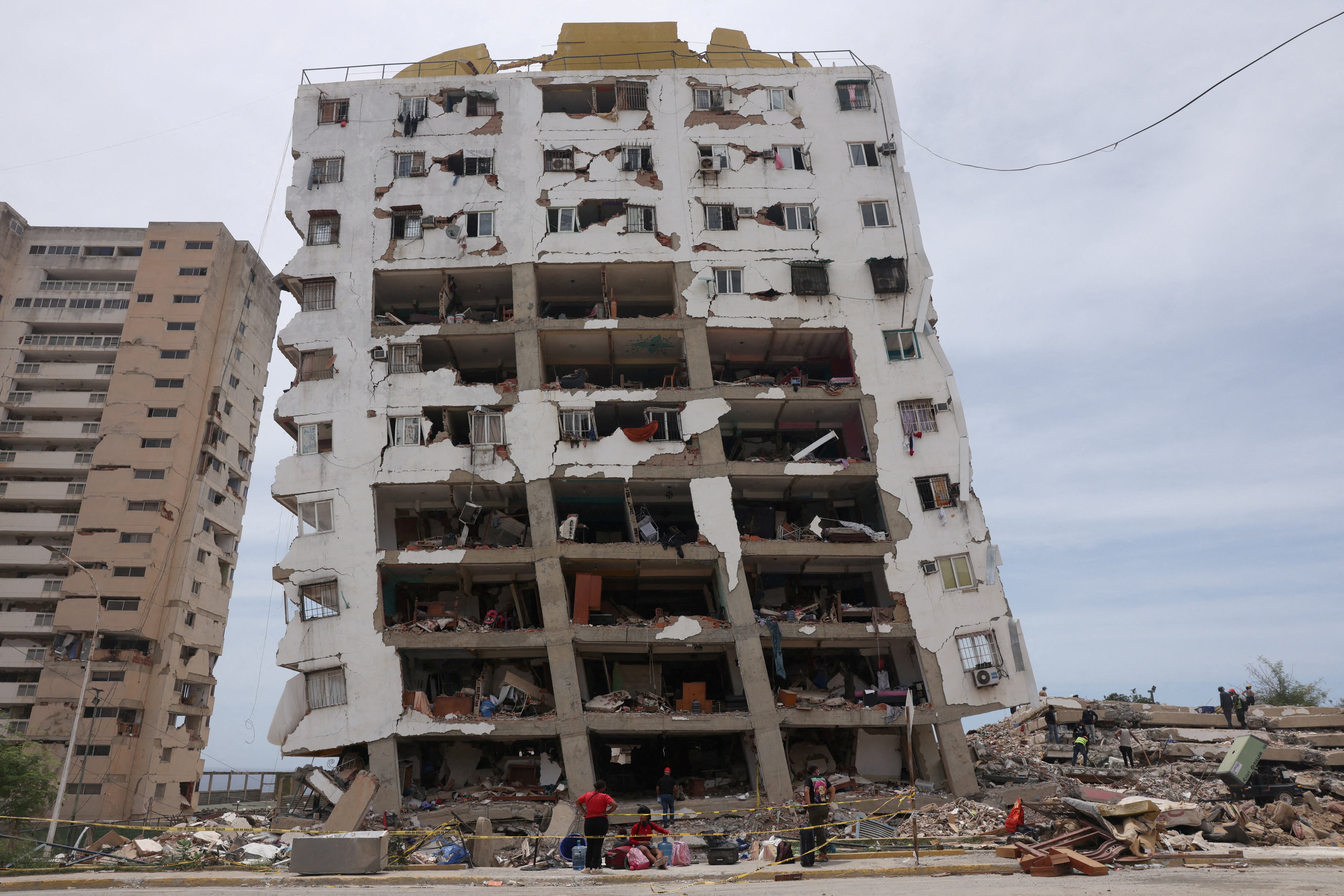 Una familia recoge sus pertenencias frente a un edificio de viviendas de «Misión Vivienda» dañado por los terremotos del 24 de junio, en Catia la Mar, estado de La Guaira, Venezuela, el 9 de julio de 2026. REUTERS/Leonardo Fernández Viloria