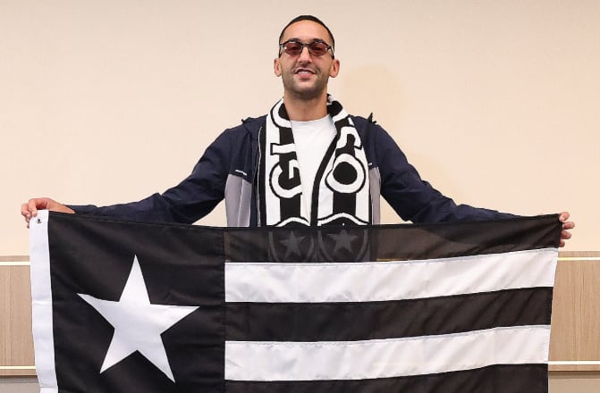 El futbolista Hakim Ziyech sostiene la bandera del Botafogo tras confirmarse su fichaje por el club de Brasil (Botafogo)