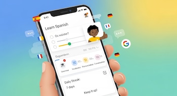 Una mano sostiene un smartphone que muestra la aplicación de Google para aprender idiomas, con elementos flotantes como el logo de Google y banderas de países.