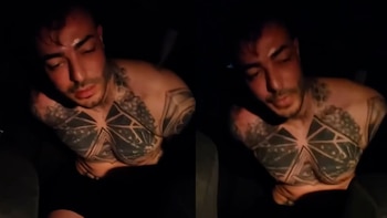 Dos tomas de un hombre con el torso descubierto y tatuajes geométricos en el pecho, sentado en un espacio oscuro con los brazos hacia atrás