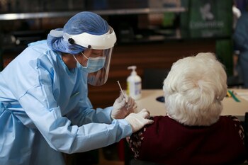 An elderly woman receives her
