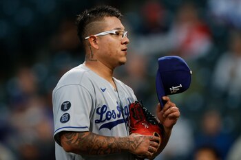 Sep 21, 2021; Denver, Colorado, USA; Los Angeles Dodgers starting pitcher Julio Urias (7) takes off his hat to be inspected after pitching against the Colorado Rockies in the first inning at Coors Field. Mandatory Credit: Isaiah J. Downing-USA TODAY Sports