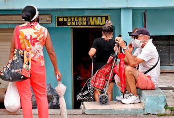 Varias personas esperan fuera de