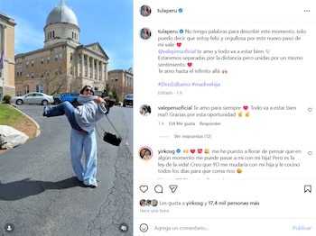 Tula Rodríguez levanta a su hija en un abrazo frente a un edificio universitario con cúpula y columnas en Nueva York. Hay autos y cielo azul