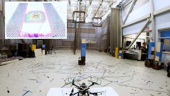 Un dron en primer plano dentro de un laboratorio con obstáculos y un gráfico digital de mapeo espacial en la esquina superior izquierda