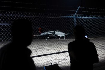 Media personnel stand at Dona