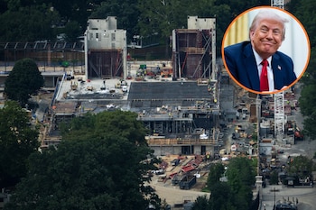 Vista aérea de las obras de construcción de un edificio con estructura de hormigón y un retrato en círculo de Donald Trump en la esquina