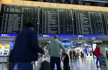 Varios viajeros comprueban el estado de sus vuelos en las pantallas de un aeropuerto. (EFE/EPA/RONALD WITTEK)