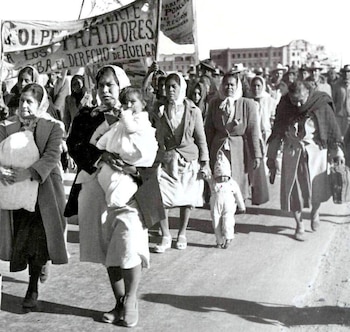Foto em preto e branco de mulheres e crianças marchando na Caravana da Fome de 1951; a maioria deles usa lenço na cabeça e roupas modestas quando anda pelas ruas