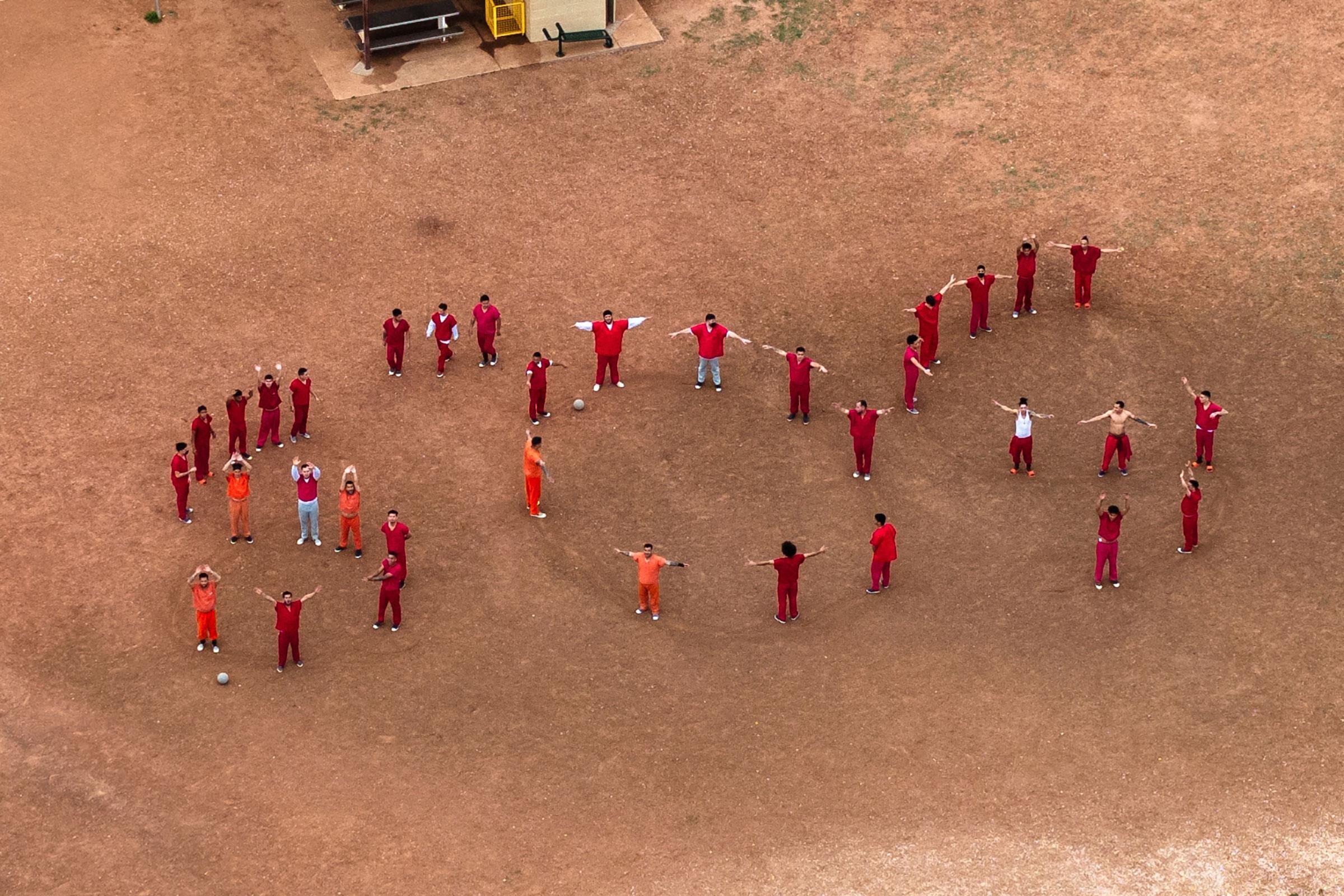 Vista aérea desde un dron de los detenidos formando las letras SOS con sus cuerpos en el patio del centro de detención Bluebonnet, donde se encontraron recluidos los venezolanos objeto de una sentencia del Tribunal Supremo de Estados Unidos, en Anson, Texas, el 28 de abril (Paul Ratje—Reuters)