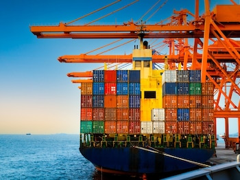 Buque portacontenedores en operaciones de carga en un puerto. (Foto cortesía Mercados y finanzas).