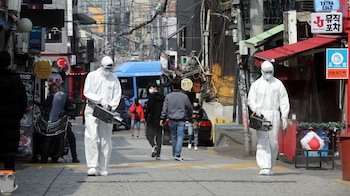 Trabajadores de cuarentena rocían desinfectantes en la zona de bares nocturnos del barrio de Itaewon, tras el brote de la enfermedad coronavirus (COVID-19), en Seúl, Corea del Sur, el 11 de mayo de 2020. Yonhap/via REUTERS