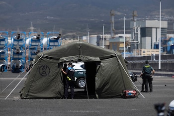 Agentes de la Guardia Civil y de la Policía Portuaria junto al puesto de mando instalado este viernes en el puerto de Granadilla con motivo de la llegada del crucero MV Hondius. EFE/ Miguel Barreto