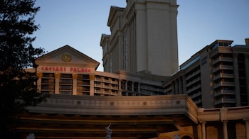 Exterior del Caesars Palace y Nobu Hotel en Las Vegas con arquitectura de estilo romano, columnas y un frontón triangular, bajo un cielo azul claro