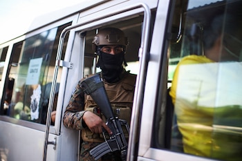 A Salvadoran soldier guards a seized transport unit in a terminal after the Salvadoran government sanctioned a bus route for violating emergency measures to alleviate the effects of high fuel prices following Russia's invasion of Ukraine, in San Salvador, El Salvador March 14, 2022. REUTERS/Jose Cabezas