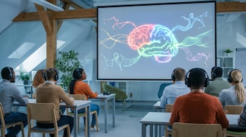 Estudiantes de diversas etnias en un aula moderna con auriculares, mirando una pantalla que muestra un cerebro animado con conexiones luminosas.