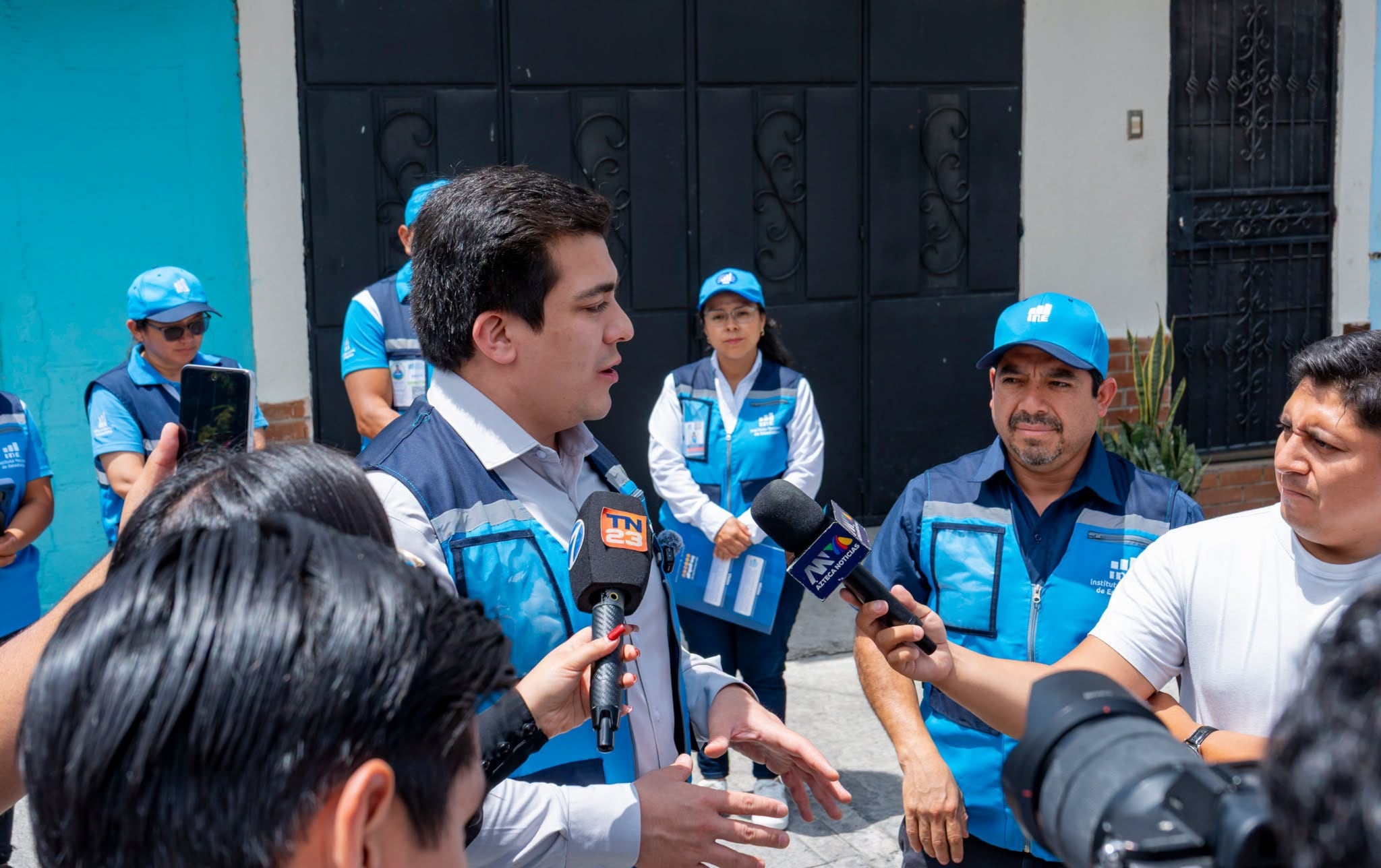 Un representante del Instituto Nacional de Estadística brinda una rueda de prensa en la vía pública ante medios de comunicación. (INE Guatemala)