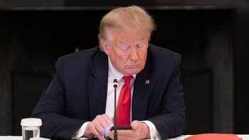 Trump mira su celular durante