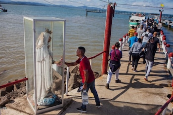 Migrantes caminan por el muelle