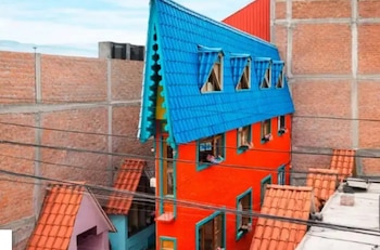 Una casa estrecha naranja y azul en Perú