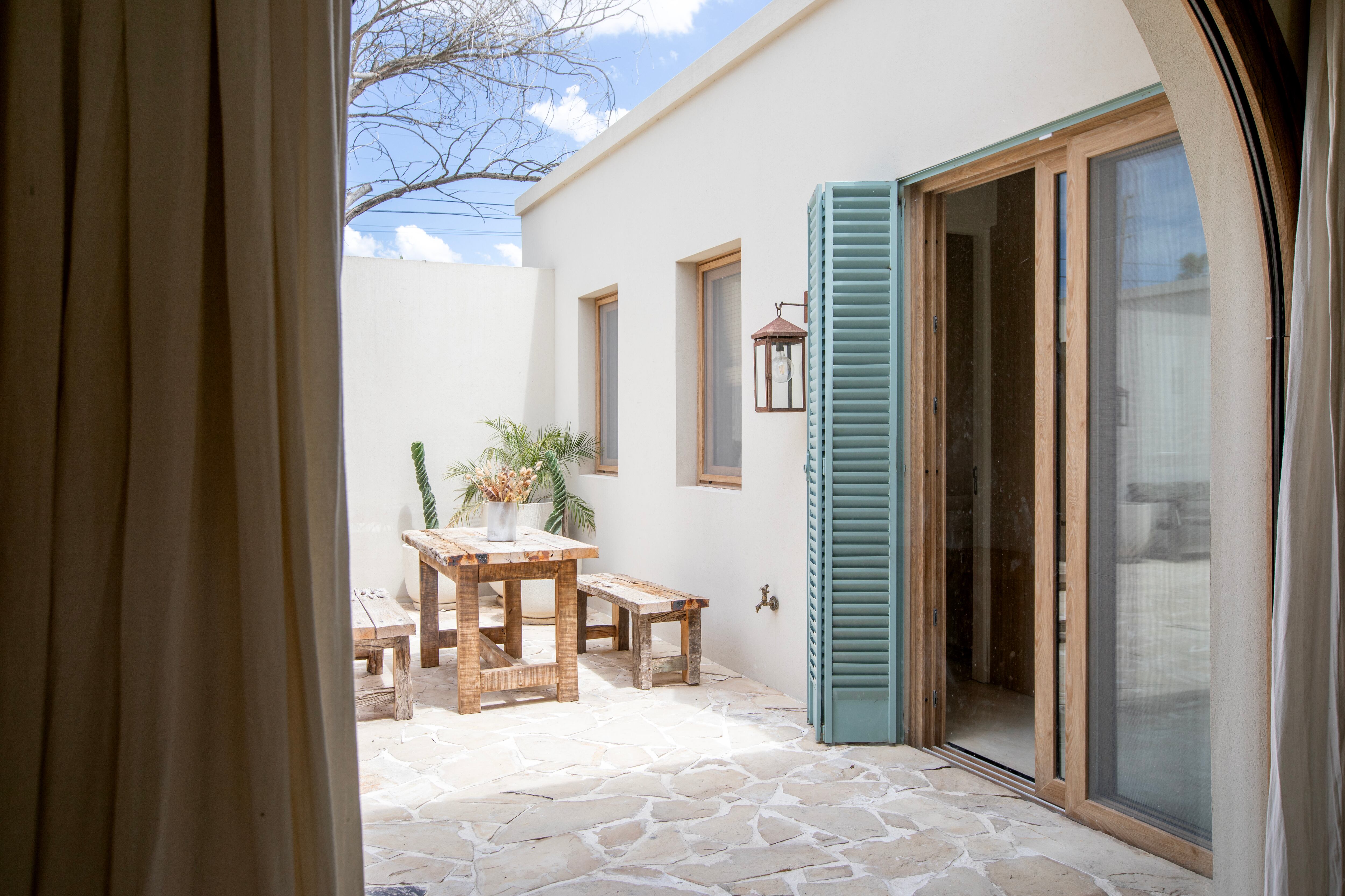 Puertas de pino rústico, arcos de PVC y la magia de un patio central