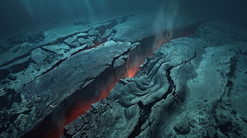 Vista del fondo marino con rocas fracturadas y una gran grieta central que emite luz roja brillante y columnas de humo.