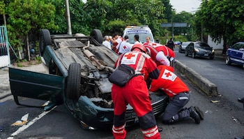 Personal de la Cruz Roja Salvadoreña auxilia a los ocupantes de un vehículo volcado durante un accidente de tránsito en plena temporada vacacional agostina (Cortesía: Cruz Roja Salvadoreña).