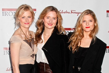 Retrato de tres mujeres rubias sonrientes. La de la izquierda lleva un top beige, la del centro una chaqueta negra, y la de la derecha un labial rojo y chaqueta oscura