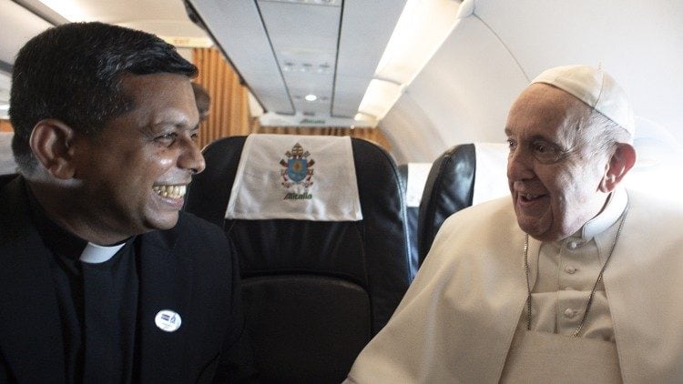 El papa Francisco conversa con el cardenal George Koovakad durante un viaje a bordo del avión papal.