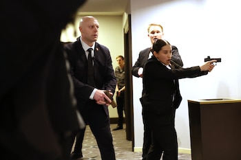 Membros das forças de segurança entraram na sala do Washington Hilton durante o jantar anual da Associação de Imprensa da Casa Branca, depois que foram disparados tiros que forçaram o presidente Donald Trump e o vice-presidente JD Vance a sair. O suposto atirador foi preso. (Foto AP/Tom Brenner)