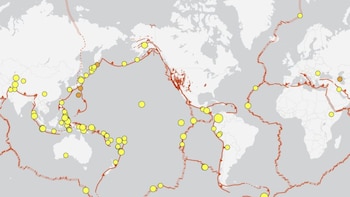 Mapa mundial con continentes y océanos, líneas rojas que representan placas tectónicas y círculos amarillos y naranjas indicando puntos de actividad