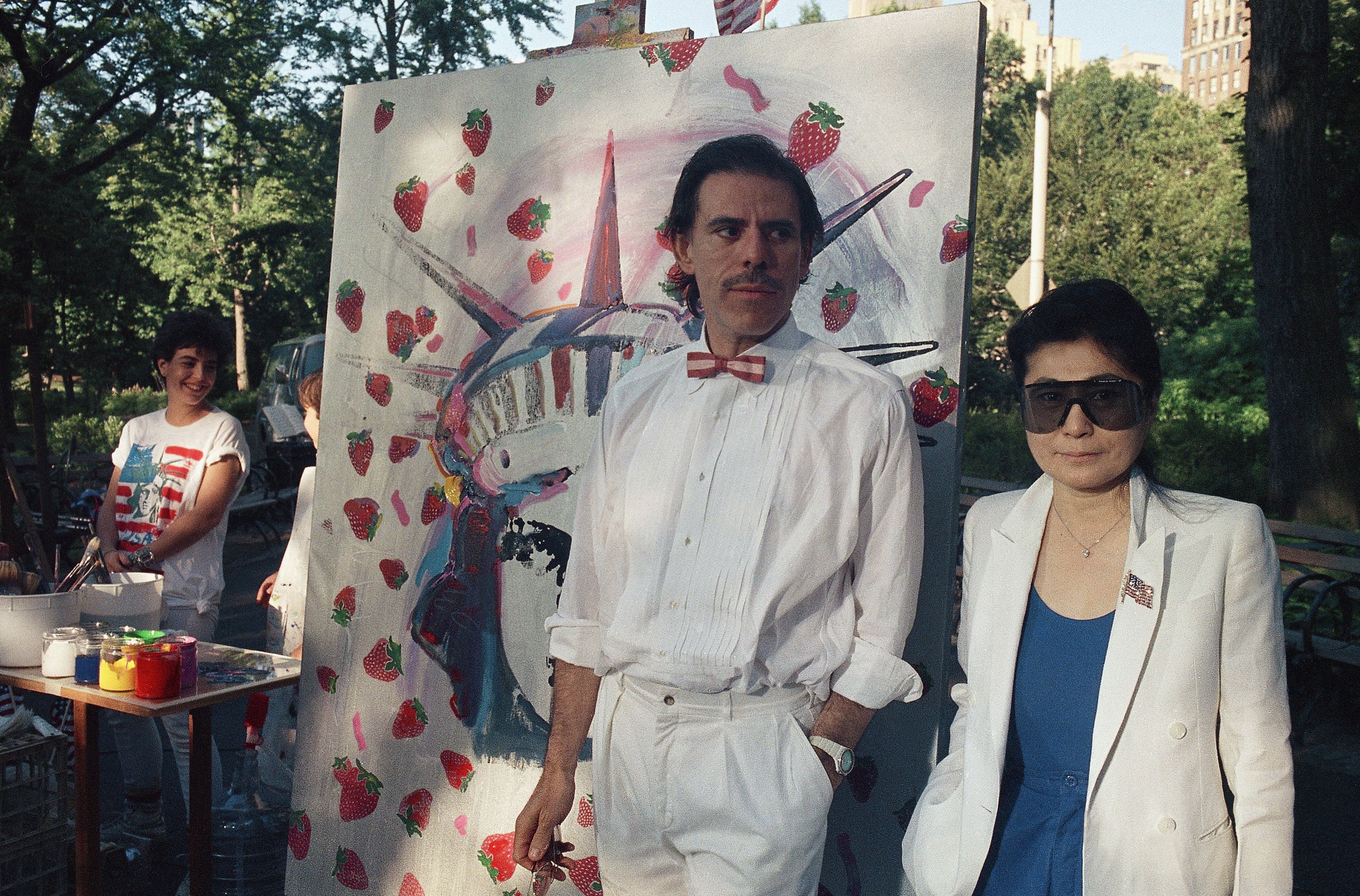 El artista Peter Max, izquierda, y Yoko Ono posan juntos en Central Park, frente a un mural que combina la Estatua de la Libertad y Strawberry Fields, el 4 de julio de 1986 en Nueva York (AP/David Bookstaver)
