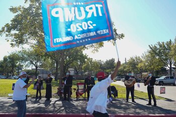 Un hombre flamea una bandera
