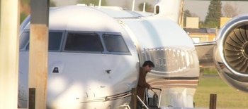 Lionel Messi desciende por la escalera de un avión privado blanco en una pista de aterrizaje