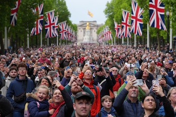 Miembros del público en el Mall observan el desfile aéreo tras la procesión militar (Carl Court/REUTERS)
