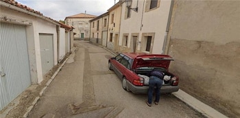 Hombre captado mientras acomoda un sospechoso saco en el maletero de su auto. (Google Street View)