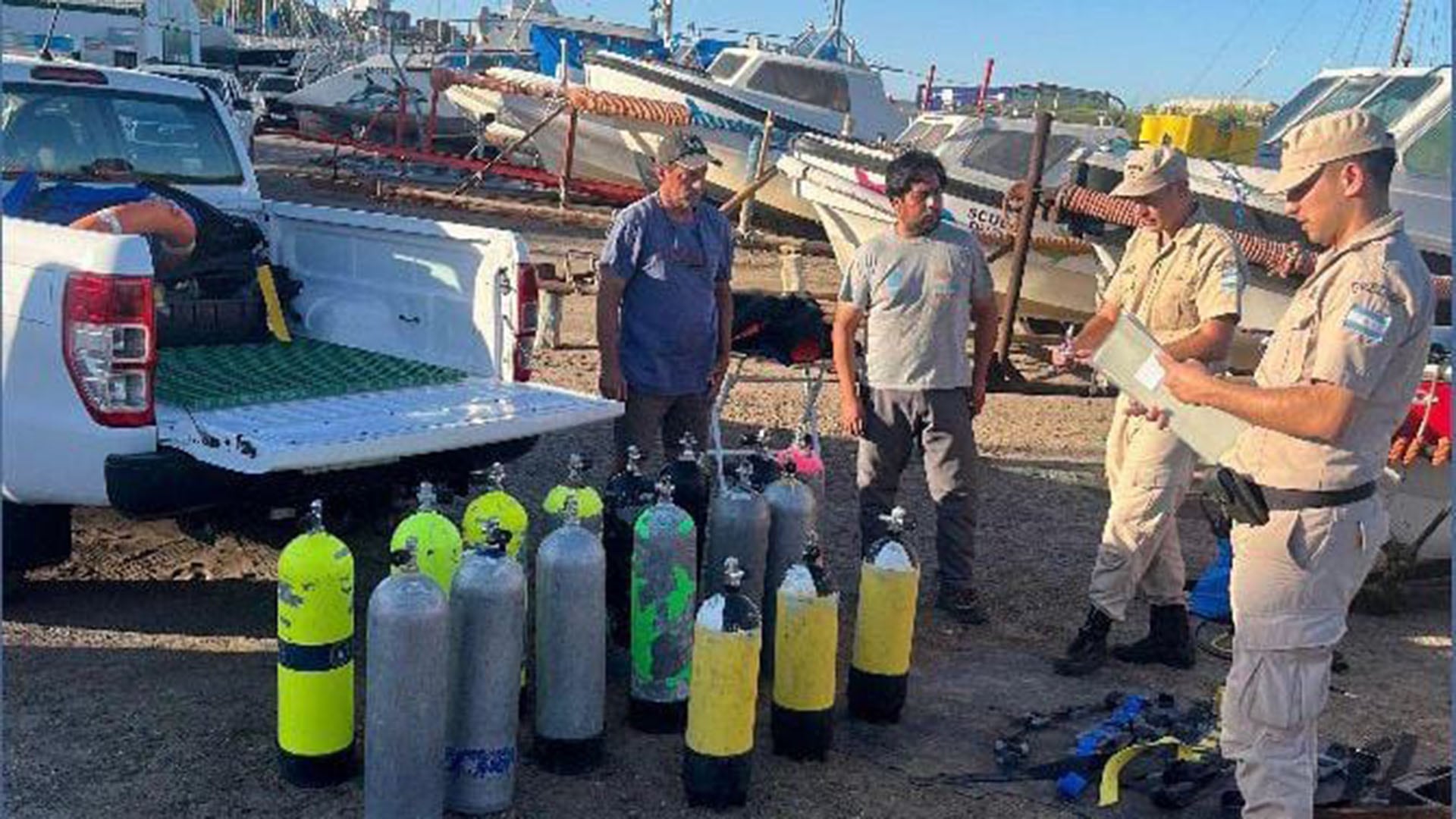 Personal de búsqueda y rescate inspecciona equipos de buceo en Puerto Madryn como parte del operativo para localizar a la mujer desaparecida.