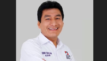 Fotografía de retrato de un hombre sonriente con camisa blanca que tiene impreso su nombre y el logotipo del partido Acción Popular
