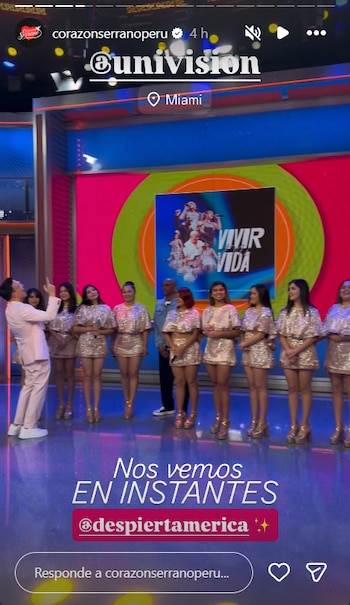 Un grupo de ocho mujeres con vestidos dorados y un hombre de traje claro posan junto a otro hombre en una escenografía de televisión con un cartel