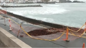 Vista aérea de un gran forado en el malecón de San Bartolo, cercado con mallas de seguridad y cinta amarilla, con el mar agitado al fondo