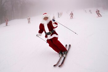 Cientos de Santa Claus desfilan por las pistas de Sunday River, contribuyendo a una buena causa. (Foto AP/Robert F. Bukaty)