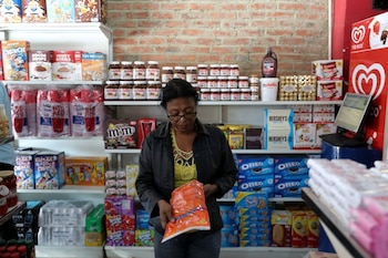 Una mujer revisa el precio de una bolsa de detergente en un bodegón en Puerto Cabello, Venezuela (REUTERS/Manaure Quintero)