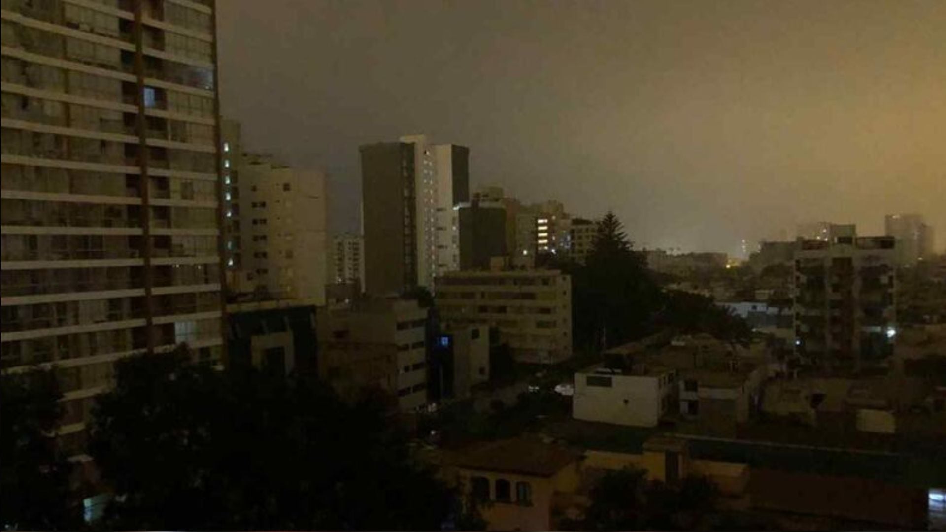 Un paisaje urbano nocturno de Lima muestra edificios residenciales con y sin iluminación, lo que indica un corte de energía en algunas zonas de la ciudad. (Andina)