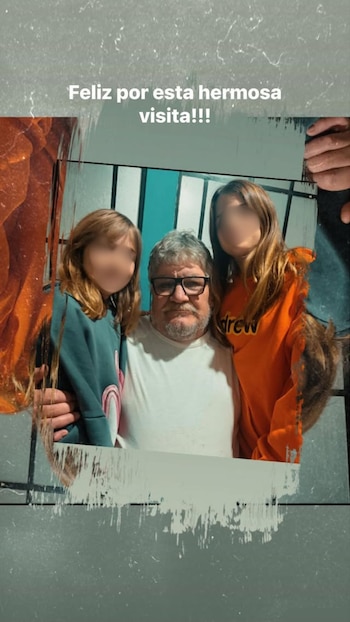 Hombre de mediana edad con gafas y barba canosa posa entre dos niñas pequeñas de cabello castaño en una foto familiar. Las caras de las niñas están pixeladas