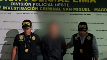 Dos policías uniformados sujetan a un hombre con el rostro pixelado. Detrás hay una pared con el logo "Policía Nacional del Perú" repetido