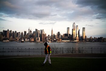 El Empire State Building y el horizonte de Nueva York se ven mientras un hombre camina por un parque local en Weehawken, Nueva Jersey, mientras el brote de la enfermedad por coronavirus (COVID-19) continúa en Nueva York (REUTERS / Eduardo Muñoz)